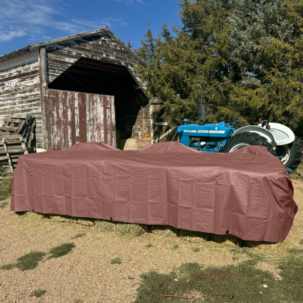 brown tarp covering hay on farm